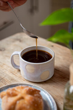 Coffee being stirred in beautiful ceramic mug