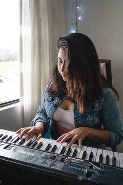 Girl playing piano in her room hobby