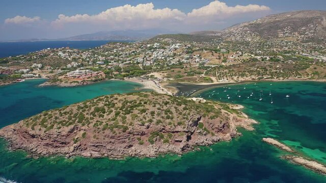 Aerial drone video of famous small islet with picturesque chapel of Agios Nikolaos and small marina, Anavissos area, Attica, Greece