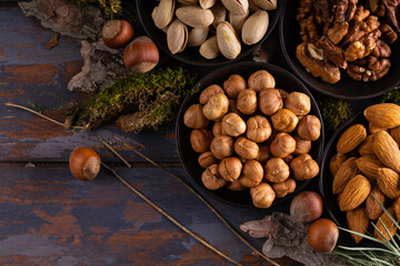 Variety of nuts in bowl on wooden background. Top view. Mixed nuts in ceramic bowl.