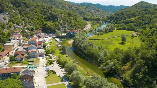 Aerial view of the the old Rijeka Crnojevica river, surrounded by picturesque green trees 
