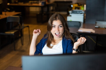 Joyful woman at her desk in the office