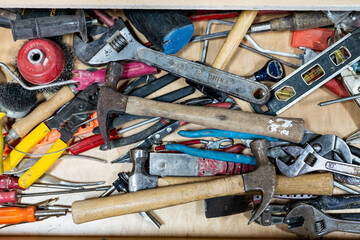 Top down view of assorted well used hand tools in work space