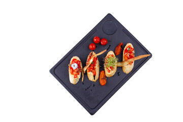 Bruschettas with ripe vegetables, beans, tomatoes, eggplant and white sauce, isolated white background.