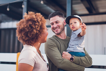 Dad holding baby boy and looking at mom
