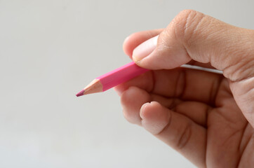 hand holding pink color pencil