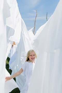Little blondes in summer play with sheets
