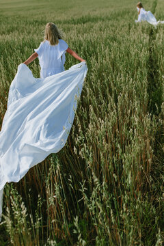 children run across the field with sheets in their hands