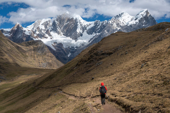 One person with a backpack hiking on a trail at Cordillera Huayhuash