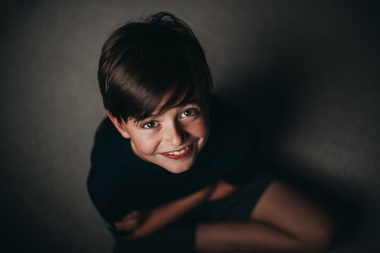 Portrait of young smiling boy with freckles shot from above.