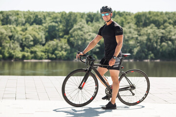 handsome young male in helmet and sunglasses with bike