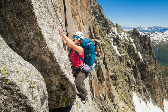 Woman rock climbs Via Amici on Lochberg, Furka Pass, Uri, Switzerland