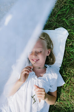 the child lies on the grass in summer