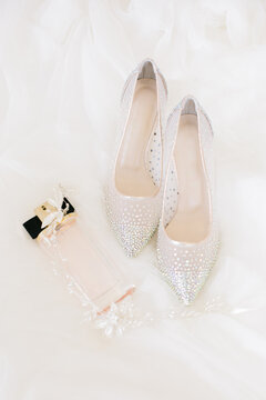 Bridal accessories. Bridal shoes, perfume and crown.