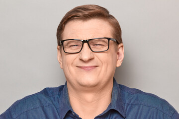 Portrait of happy optimistic man with glasses, smiling cheerfully