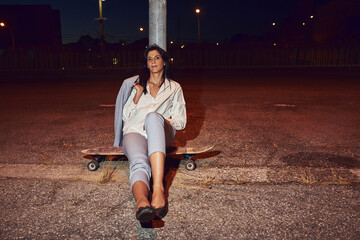 Woman with a long-board at dusk.