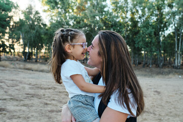 mom plays with her daughter on the field