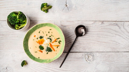 Traditional recipe of broccoli cheese soup with vegetables in a bowl with toast, homemade healthy organic vegetarian vegan diet fresh food meal dish soup lunch, space for text. top view