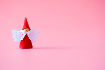 figurine of a Christmas angel on a pink background, new year