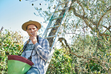 farmer smokes a cigarette sitting on the stairs taking a break