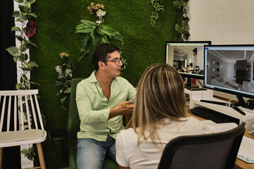young guy shows his client projects that he has in his hands in order