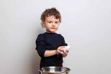 the boy is soaping his hands. Hygiene rules and good habits. The child washes his hands with a dense soap bar on a white studio background. isolated