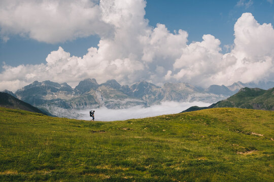 Young man hikes at Mt Aspe in the Pyrenees, while carrying his son.