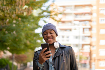 happy young african man in the city listening to music