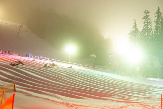 A group of people slide down a snowhilll on tubes in Oregon.