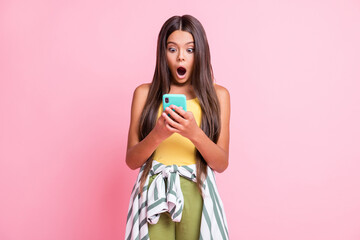 Photo of shocked brown long haired little girl open mouth wear yellow singlet isolated on pink color background