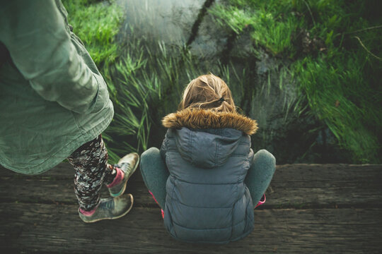 children on bridge over pond