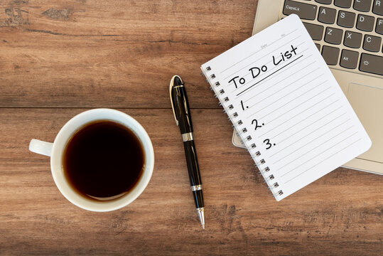 To do list text on notepad on top of laptop with cup of coffee and pen