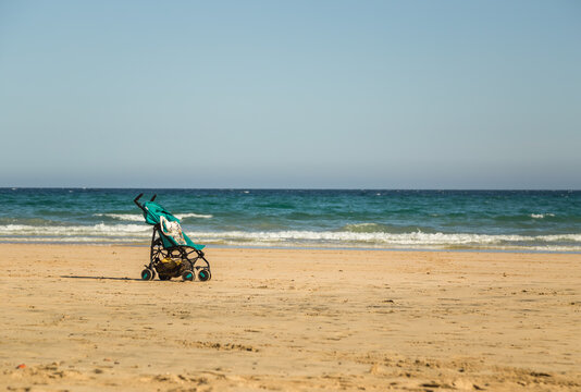 Beautiful empty sandy beach with an infant baby stroller in Fuerteventura, Canary Islands, Spain.
