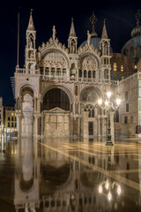Fototapeta na wymiar Cattedrale di San Marco (St. Mark Cathedral) by night with acqua alta (high water) on San Marco Square in Venice, Venezia