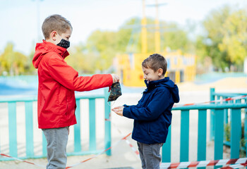little boy handing a mask to his brother