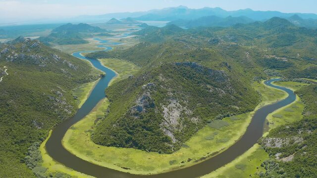 Aerial view of the the old Rijeka Crnojevica river, surrounded by picturesque green trees