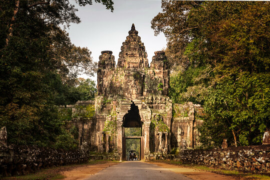 Angkor Archaeological Park, Siem Reap, Cambodia. Tuk Tuk drives through narrow Victory Gate of Angkor Thom.