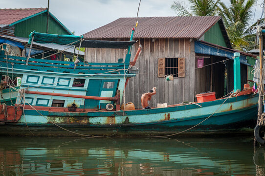 KAMPOT PROVINCE, CAMBODIA - 18 December 2013: Fisherman washes his hair on his boat.