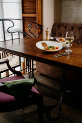 Fresh salad plate with shrimp, tomato and mixed greens on wooden background close up. Healthy food. Clean eating.