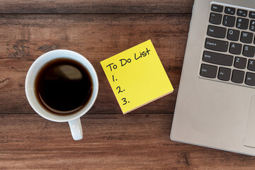 To do list text on adhesive paper note with laptop and cup of coffee and pen