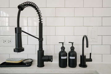 Kitchen sink with black fixtures and soap