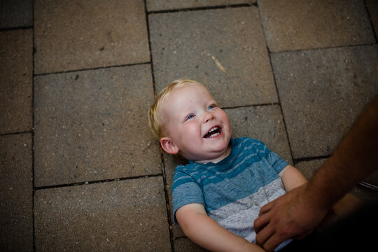 Uncle Tickling Nephew Laying on Ground in San Diego