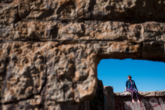 woman sitting on a wall at the sutro baths in san francisco