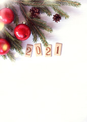 red balls with lights on fir branches on a light background with a place for inscriptions. board for wishes in 2021