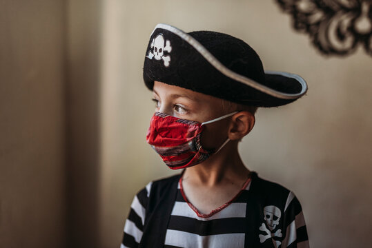 Lifestyle portrait of young boy dressed as pirate with face covering