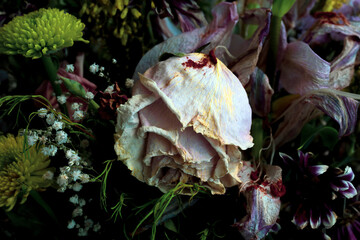 Bouquet of withered flowers with a dried rose in the foreground