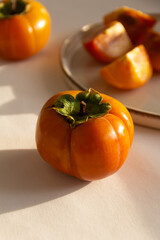 Fresh bright orange autumn persimmon on white background