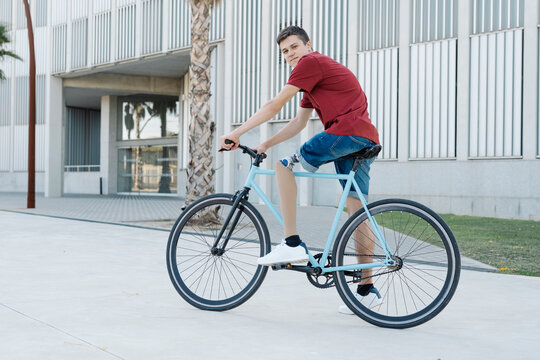 Young disabled cyclist riding bike in city