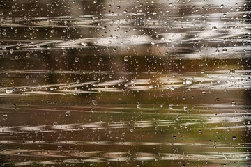 Transparent cling film texture with drops on the surface and highlights on brown green autumn background
