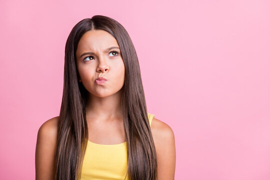 Photo portrait of thoughtful girl looking at blank space isolated on pastel pink colored background